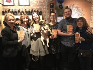 A group of happy booksellers hold copies of The Muralist by B.A. Shapiro